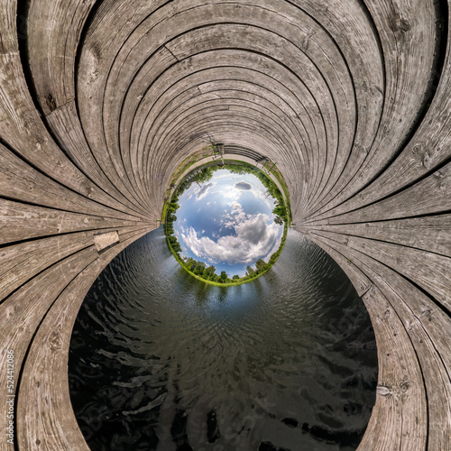 blue sphere little planet inside transformation of wooden pier and lake.