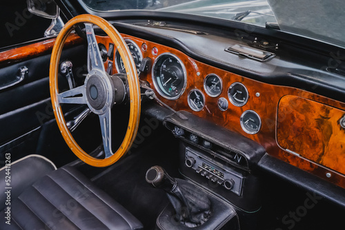 Interior of a retro sports car with steering wheel and dashboard