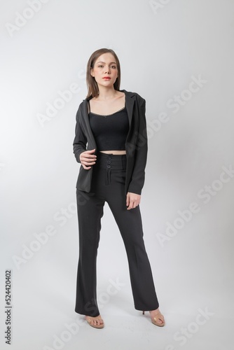 Full length body portrait of a young beautiful asian female businesswoman wearing full black business attire and pose with different gestures & emotions. Suitable for business presentation or slides.