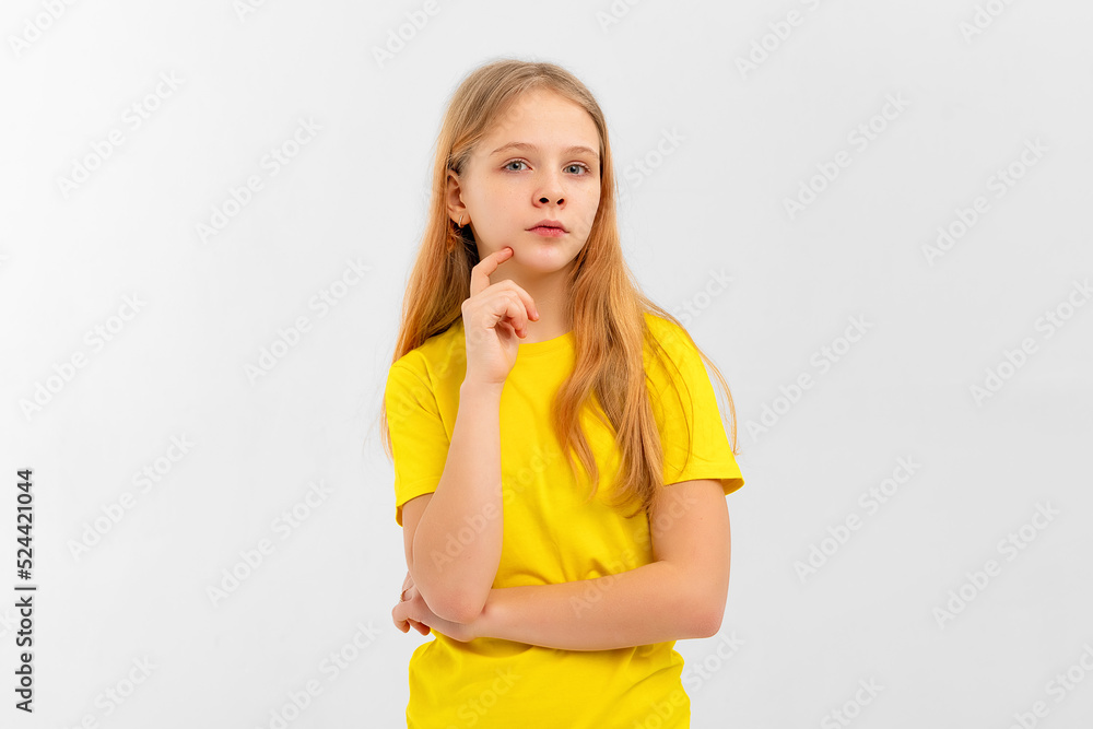 Dreamy nice pretty teen girl touch chin, thought choose decide solve problems dilemmas, wears yellow tshirt. Indoor studio shot on white background Dreamy nice pretty teen girl touch chin, thought choose decide solve problems dilemmas, wears yellow tshirt. Indoor studio shot on white background