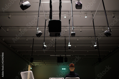 Young man listening to sound music surround installation with many speakers above