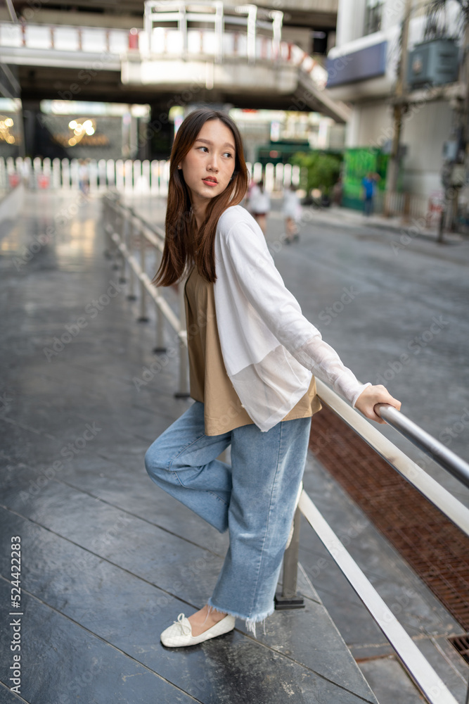 Lifestyle portrait photo of a beautiful young asian lady relax and posing around the city after a long pandemic lockdown