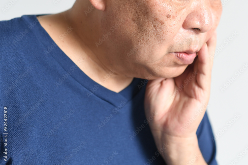 Obraz premium 頬を抑える中高年の男性