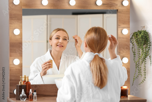 Mature woman using cosmetic...