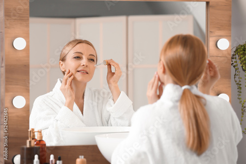 Mature woman using cosmetic...