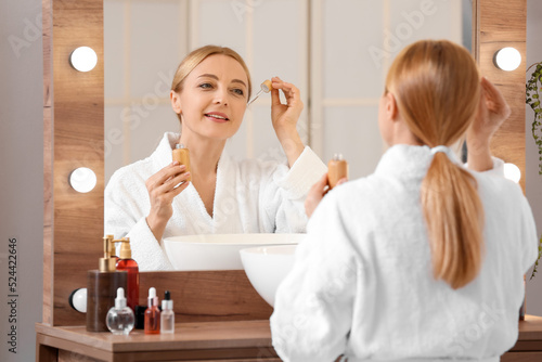 Mature woman using cosmetic...