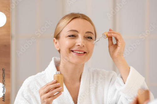 Mature woman using cosmetic...