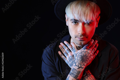 Young tattooed man on black...
