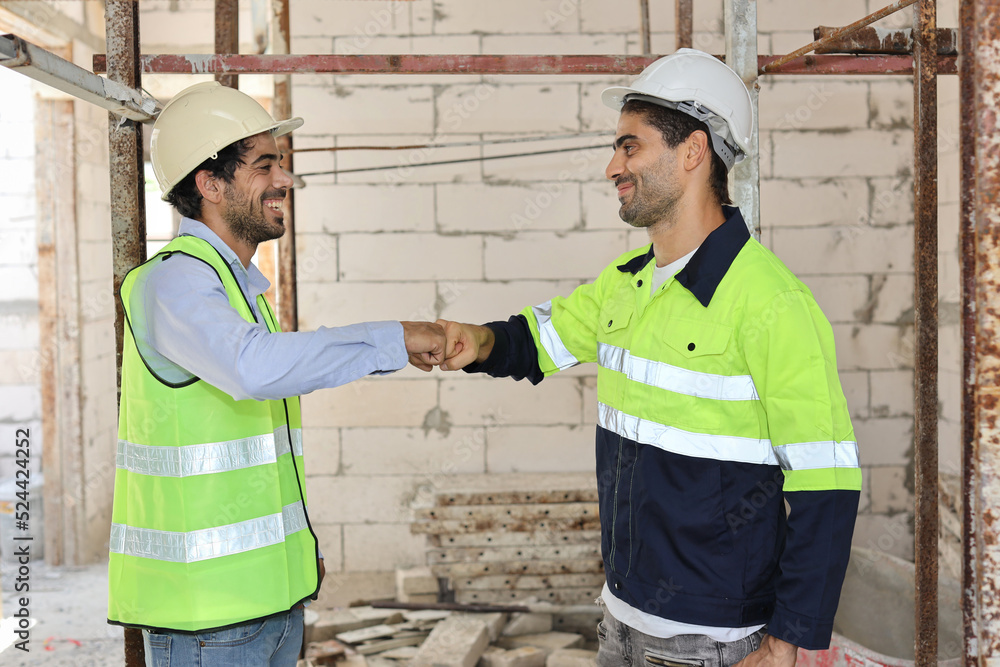 Two technician civil engineer or specialist inspector making fist bumping celebrate successful together completed deal commitment at Industrial building site. Construction concept Two technician civil engineer or specialist inspector making fist bumping celebrate successful together completed deal commitment at Industrial building site. Construction concept