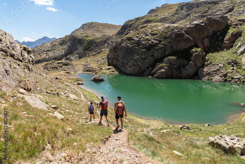 Hikers descending from Peyreget next to a lake