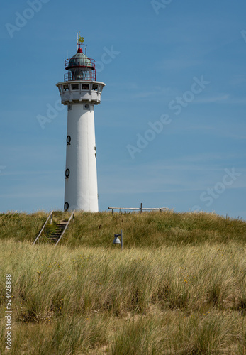 Vertical shot of white lighthouse in dutch coastal village Egmond aan Zee