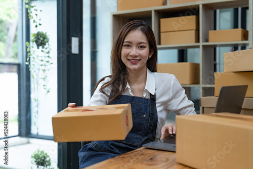 Portrait business Asian woman with parcel shipping box before send to customer. Entrepreneur small business working at home.