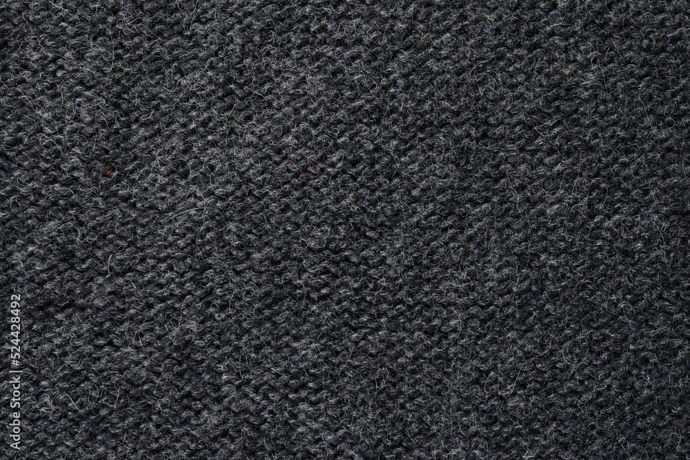 Fototapeta premium Knitted gray pattern closeup. Soft sweater texture, detailed yarn background. Natural woolen fabric, a fragment of a jersey pullover. Trendy backdrop for print, web design.