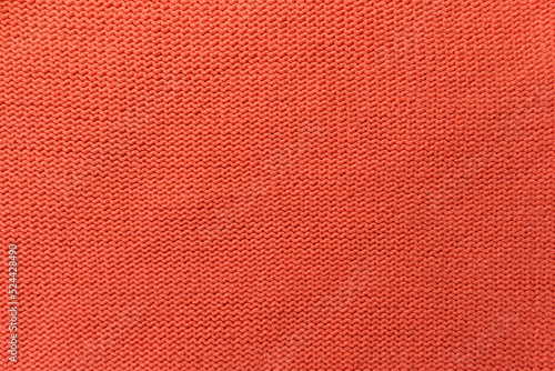 Knitted orange pattern closeup. Soft sweater texture, detailed yarn background. Natural woolen fabric, a fragment of a jersey pullover. Trendy backdrop for print, web design. © taylon