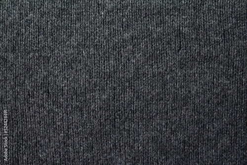 Knitted gray pattern closeup. Soft sweater texture, detailed yarn background. Natural woolen fabric, a fragment of a jersey pullover. Trendy backdrop for print, web design.