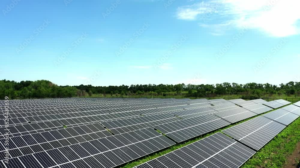 Amazing bird's eye view of solar panels standing in a row in the fields, green energy, landscape, electricity, ecology, innovation, nature, environment, slow motion. Vast area of farmland now covered Amazing bird's eye view of solar panels standing in a row in the fields, green energy, landscape, electricity, ecology, innovation, nature, environment, slow motion. Vast area of farmland now covered