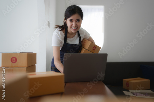 Attractive Asian SME business woman working at home office. online shopping concept