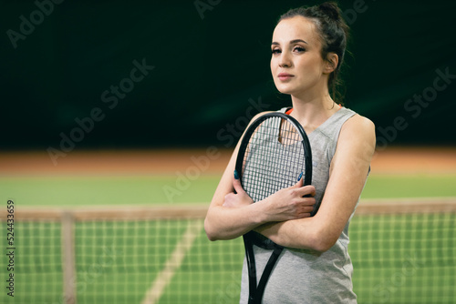 Tennis woman player portrait with racket and ball at court. © primipil