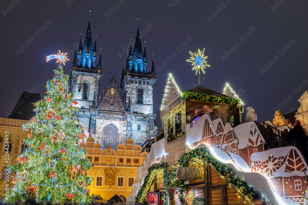 Christmas scene outdoors with tree and fairy tale decorations, in front of Our Lady Tyn Church in Prague, Czech Republic.