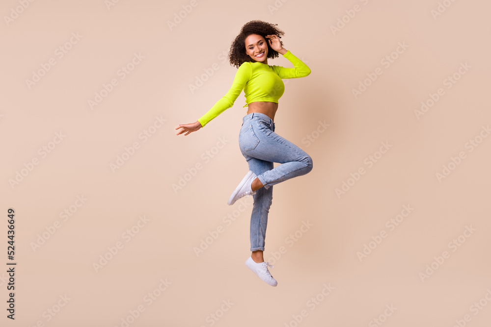 Full length body photo of young smiling adorable girl dancing jump celebrate healthy mestruation isolated on beige color background Full length body photo of young smiling adorable girl dancing jump celebrate healthy mestruation isolated on beige color background