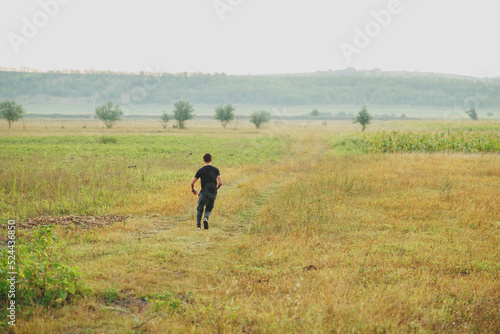 Man running through a fielt at beautiful sunny weather. Healthy lifestyle © Viorel