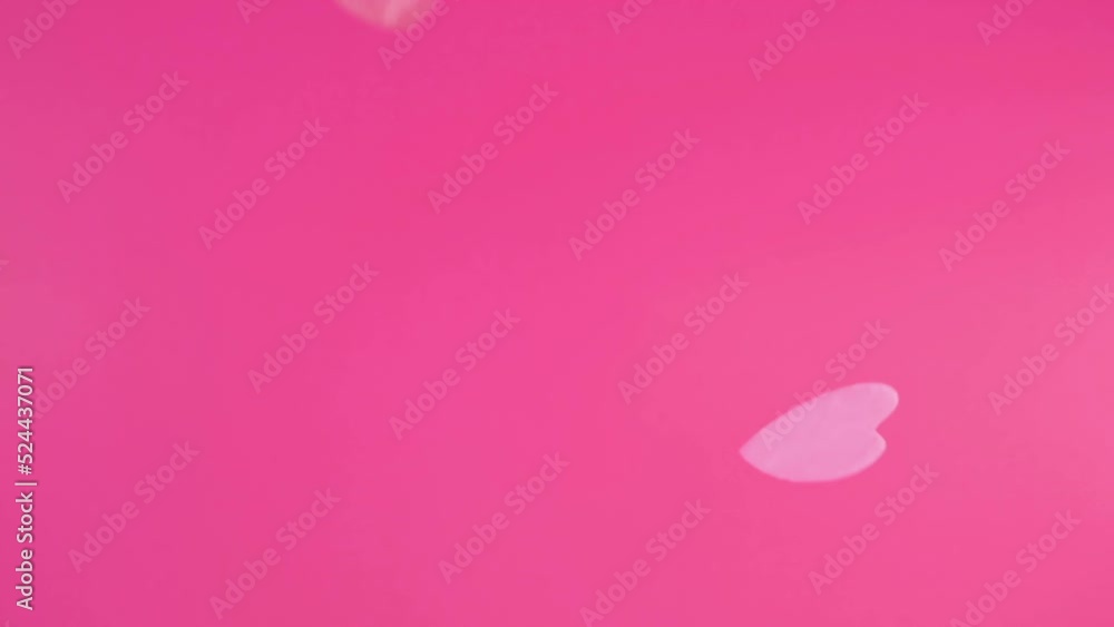 Falling confetti on a pink background. Slow motion. Falling confetti on a pink background. Slow motion.