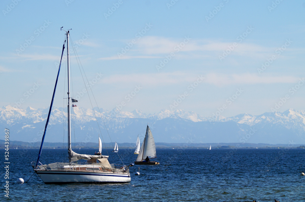 beautiful sailing boats on scenic and vast lake Ammersee with the snowy Alps in the background on a fine day in April Bavaria, Germany	
