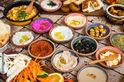 Traditional Turkish Village Breakfast on the ceramic table with pastries, vegetables, greens, spreads, cheeses, fried eggs, jams. Top view