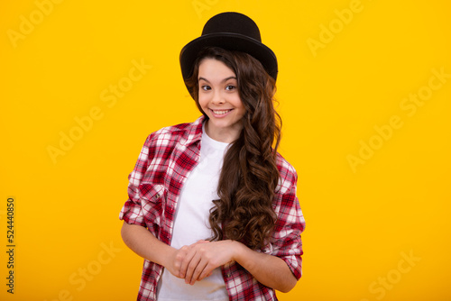 Child in magician hat, cylinder hat isolated on yellow background.