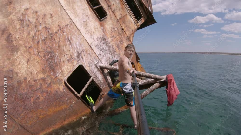 A young caucasian couple is taking a selfie and having fun while sitting on a sunken merchant ship in the middle of the open ocean. Snorkeling on sunken ships A young caucasian couple is taking a selfie and having fun while sitting on a sunken merchant ship in the middle of the open ocean. Snorkeling on sunken ships
