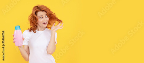 Beautiful woman with organic shampoo over light yellow background. curly hair. Woman isolated face portrait  banner with copy space.