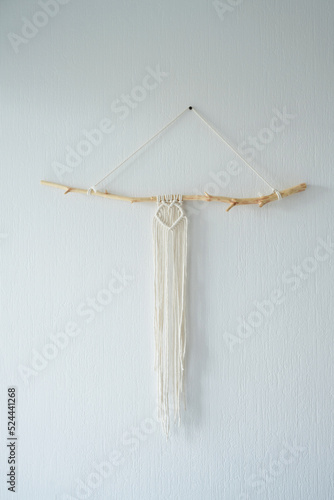Handmade macrame panel hanging on the wall in the form of a heart