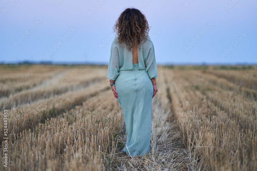 Caucasian woman in a field at sunset Caucasian woman in a field at sunset
