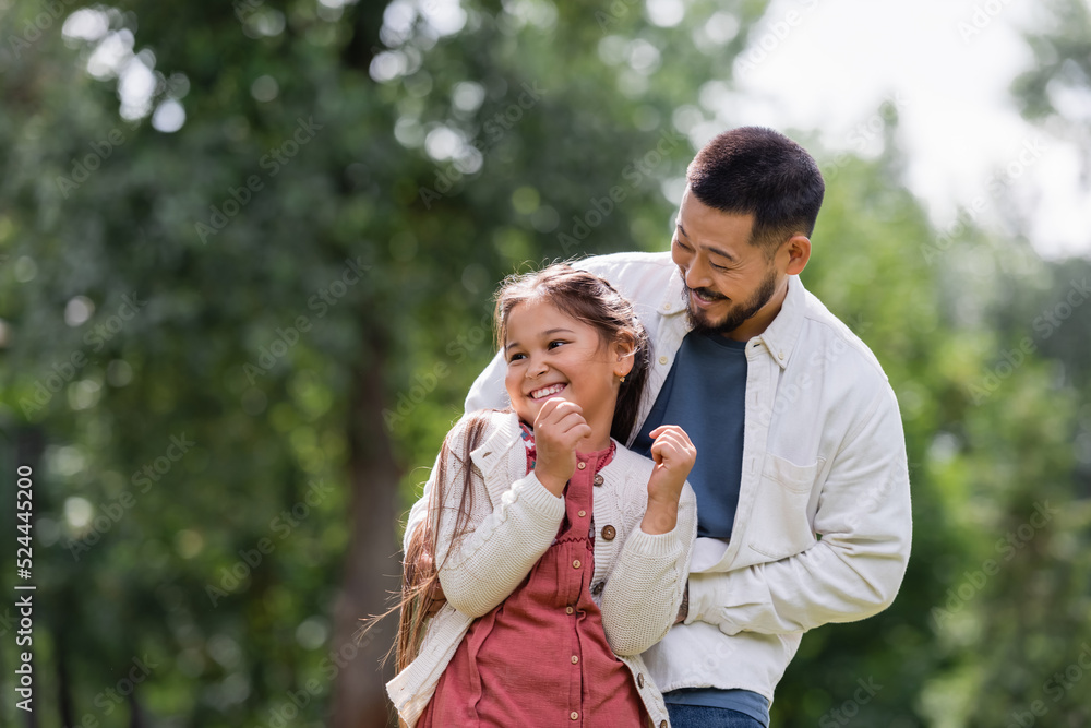 Bearded asian father playing with daughter in park. Bearded asian father playing with daughter in park.