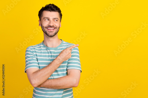 Closeup photo of young attractive guy finger directing look empty space yeah shopping sale isolated on yellow color background