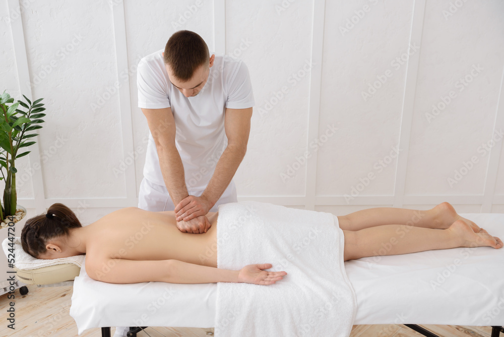 Young pretty woman having back massage in spa, white background. Copy space, closeup Young pretty woman having back massage in spa, white background. Copy space, closeup