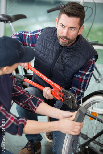 repairman using pliers for bicycle repairing indoors