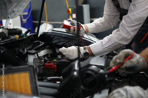 Car repair technicians use voltage multimeter to work in auto repair shops