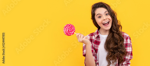 lollipop child. hipster kid with long curly hair hold lollypop. sugar candy on stick. Teenager child with sweets, poster banner header, copy space.
