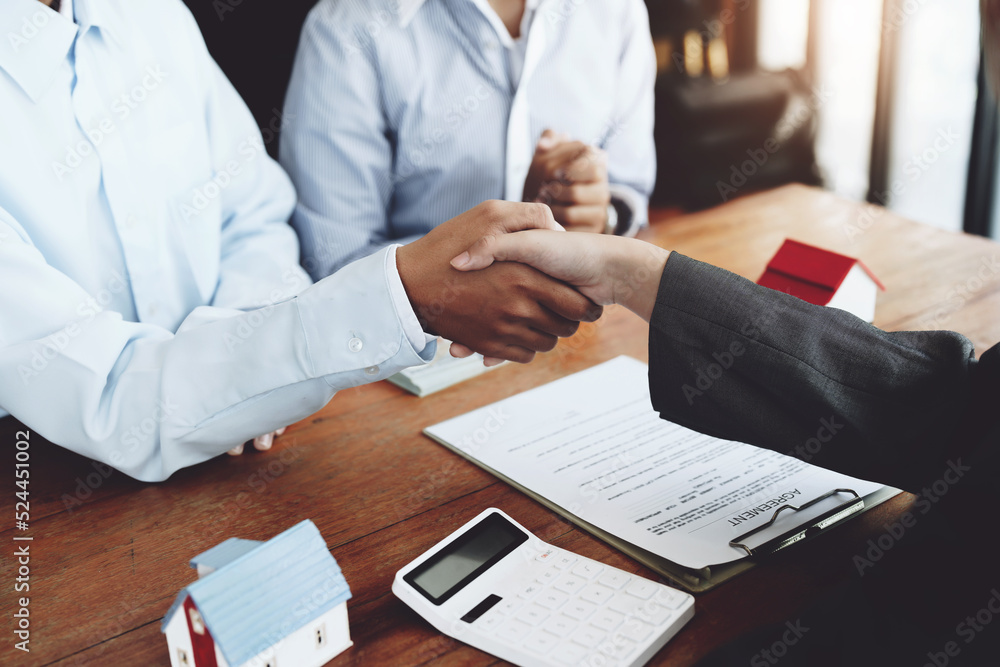 Real estate agents shake hands with customers after signing documents Real estate agents shake hands with customers after signing documents