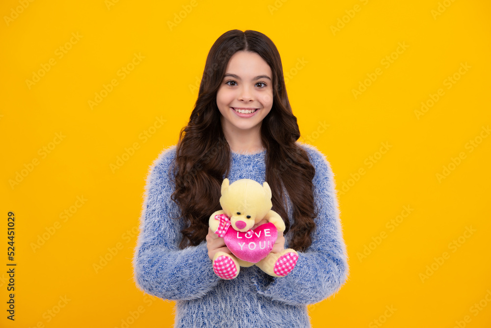 Teen girl child in casual wear holding plush toy isolated on yellow background, happy childhood. Happy teenager, positive and smiling emotions of teen girl. Teen girl child in casual wear holding plush toy isolated on yellow background, happy childhood. Happy teenager, positive and smiling emotions of teen girl.
