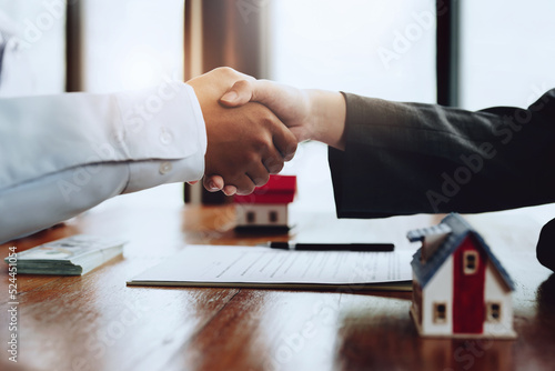 Real estate agents shake hands with customers after signing documents