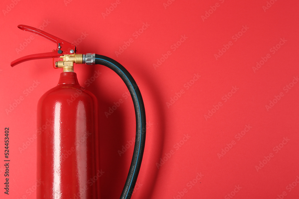 Fire extinguisher on red background, top view. Space for text Fire extinguisher on red background, top view. Space for text