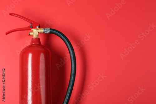 Fire extinguisher on red background, top view. Space for text