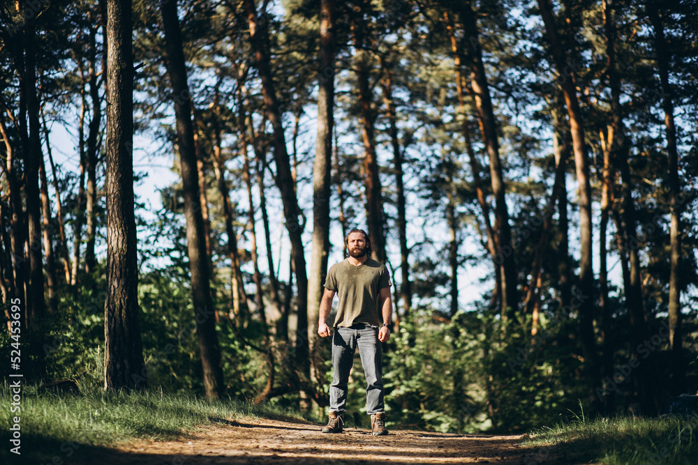 Obraz premium Handsome man standing in forest