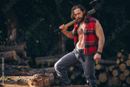 Male lumberjack  with an axe in forest
