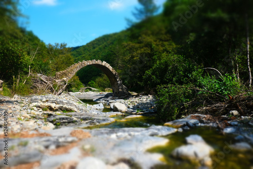 ancient arch bridge in the ligurian alps with photo effect filter