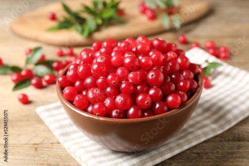 Bowl with tasty ripe cranberries on table, closeup