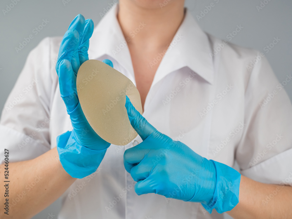 A plastic surgeon shows a breast silicone implant. A plastic surgeon shows a breast silicone implant.