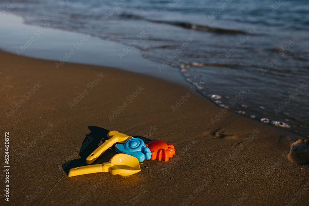 colorful sand child toys on seashore by the sea